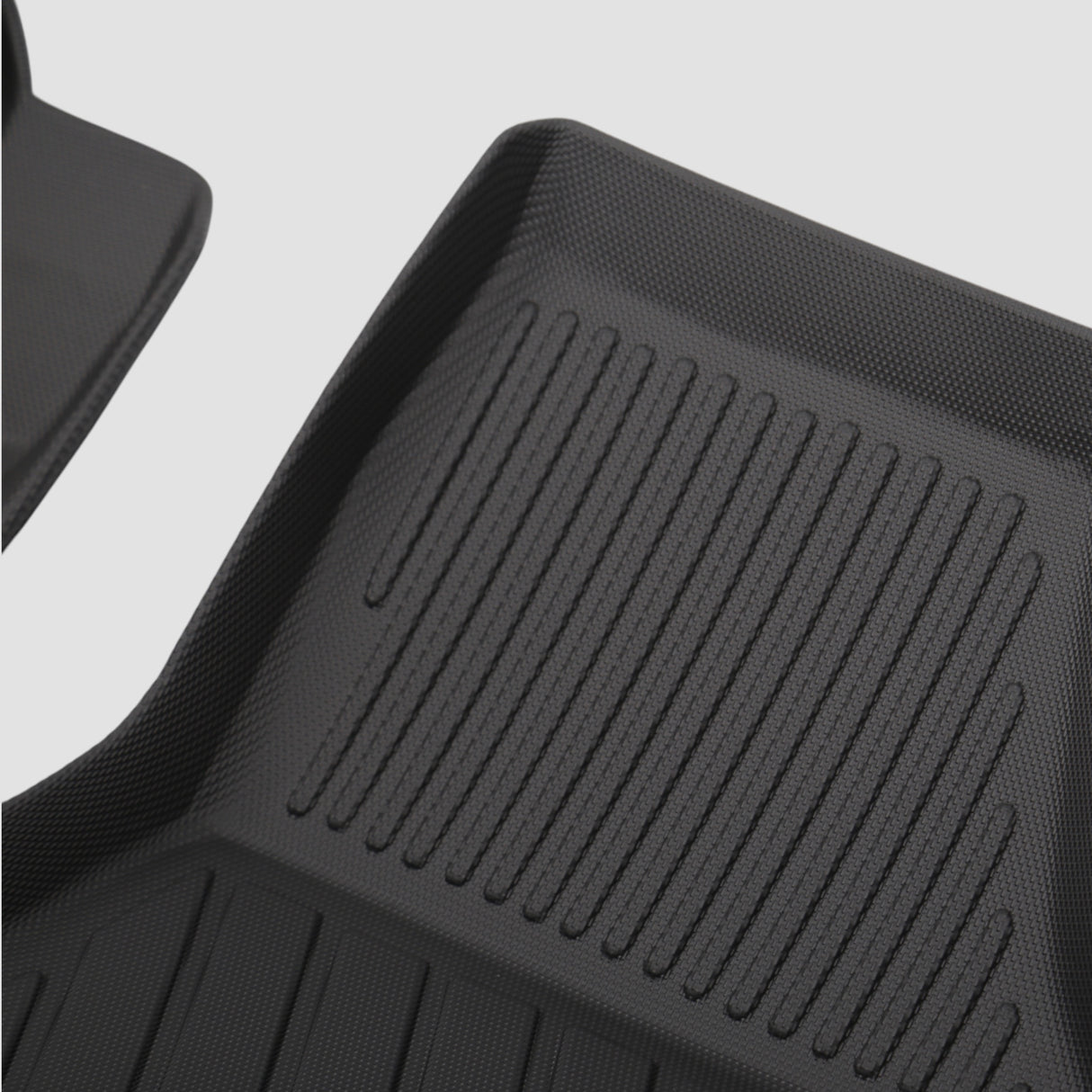 Details van een zwart 3D All Weather mattenset met groeven voor de kofferbak van de auto.