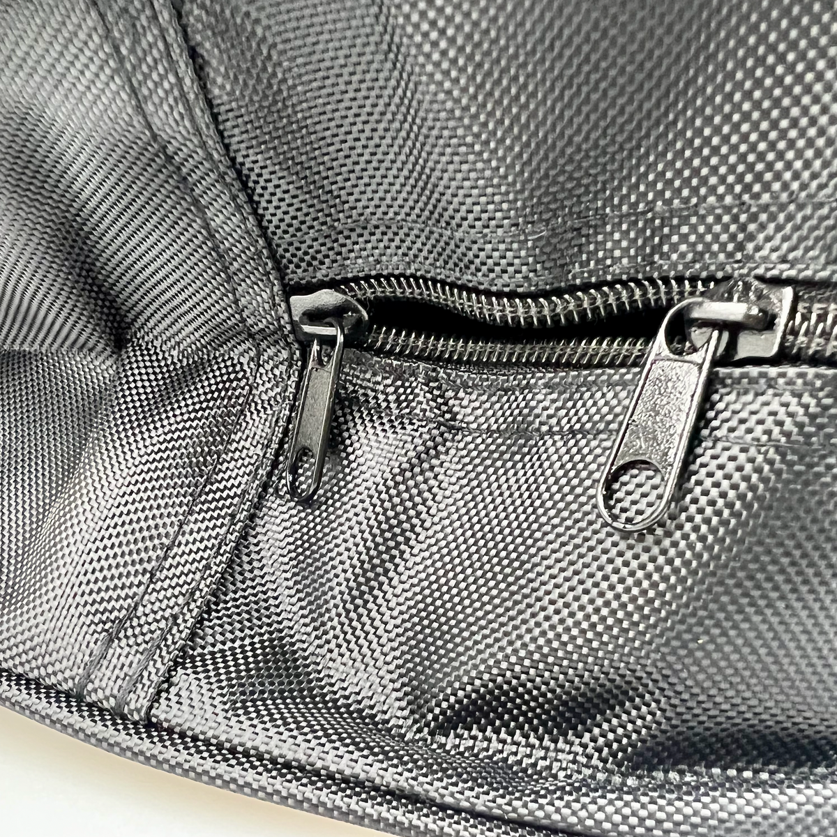 Details van een zwarte opbergtas voor laadkabel met ritssluiting