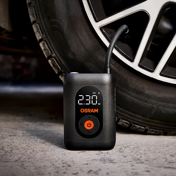 Osram TYREinflate 1600 står på asfalt ved sort alufælg med tilsluttet luftslange