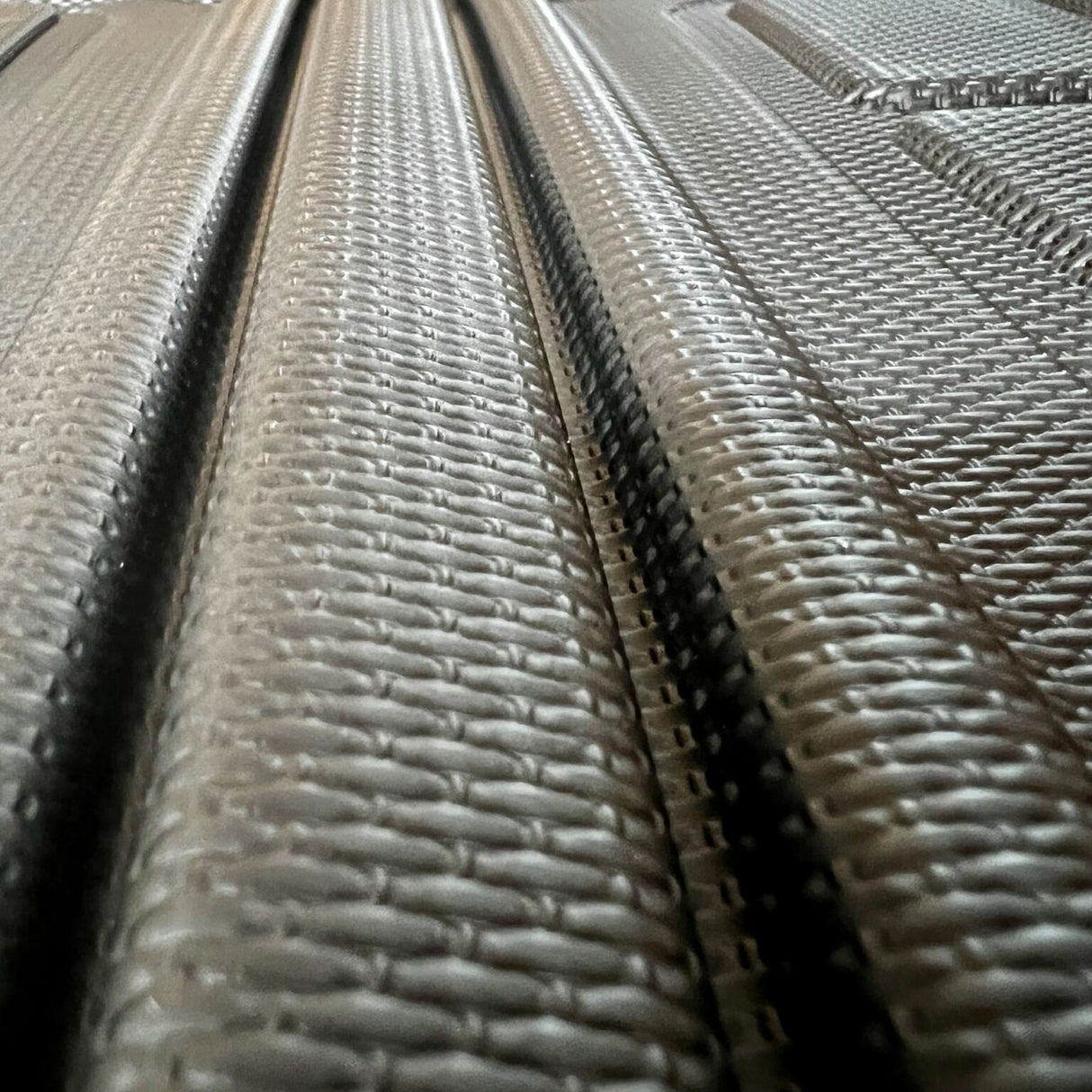Close-up van een zwarte kofferbakmat met een gestructureerd antislippatroon