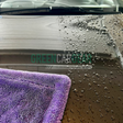 Maxshine-handdoek die water van een auto droogt.