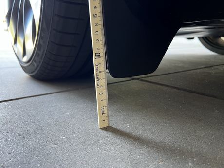 Originele spatborden op Tesla Model Y gemeten met liniaal.