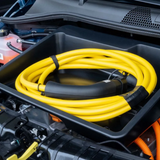Frunk opbergdoos met opgerolde laadkabel in de voorbagageruimte van een auto.