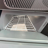 Koelkast voor Tesla Model Y met open deur en geïntegreerde plank, van binnenuit gezien.