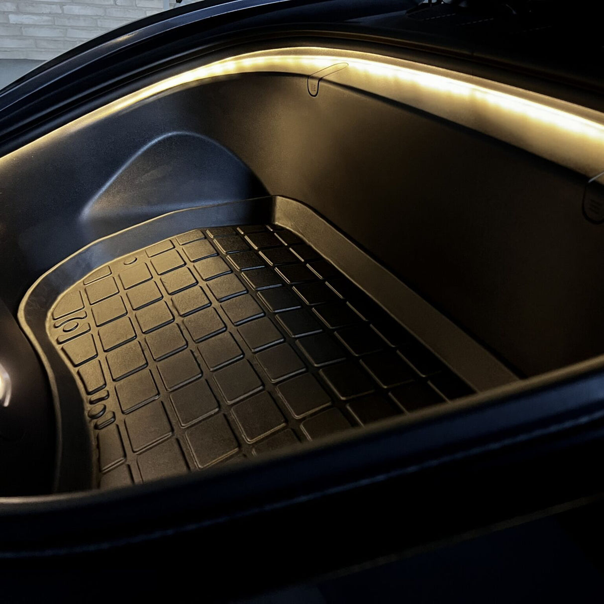 Tesla frunk met LED-lichtstrip en rubberen mat.