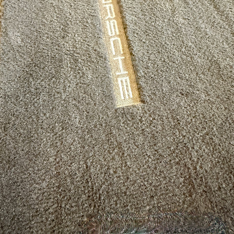 Na-foto van een schone automatten met Porsche-logo na gebruik van de stofzuiger