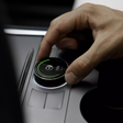 Persoon stelt S3XY Knop in voor Tesla Model 3/Y met regen-display.