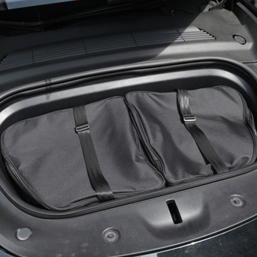 Tasset met twee zwarte opbergtassen in de frunk van een Tesla Model Y.