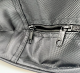 Details van een zwarte opbergtas voor laadkabel met ritssluiting
